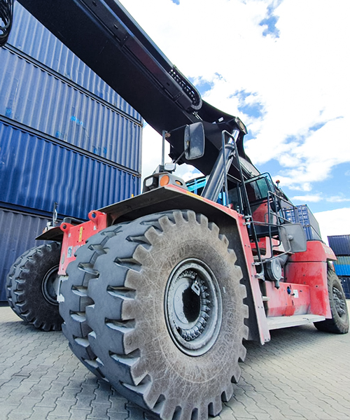 Magna M-STACKER tyre fitted on a reach stacker, designed for maximum traction and durability in demanding port and logistics environments.