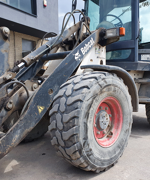 MA11 construction tyre on a compact wheel loader, designed for optimal grip and wear resistance on rough terrains.