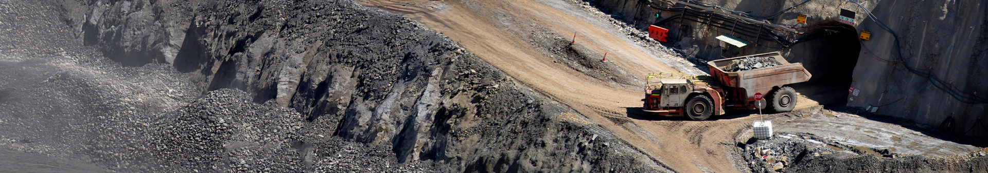 Underground dump truck fitted with durable underground dump truck tires transporting mined materials from a tunnel.